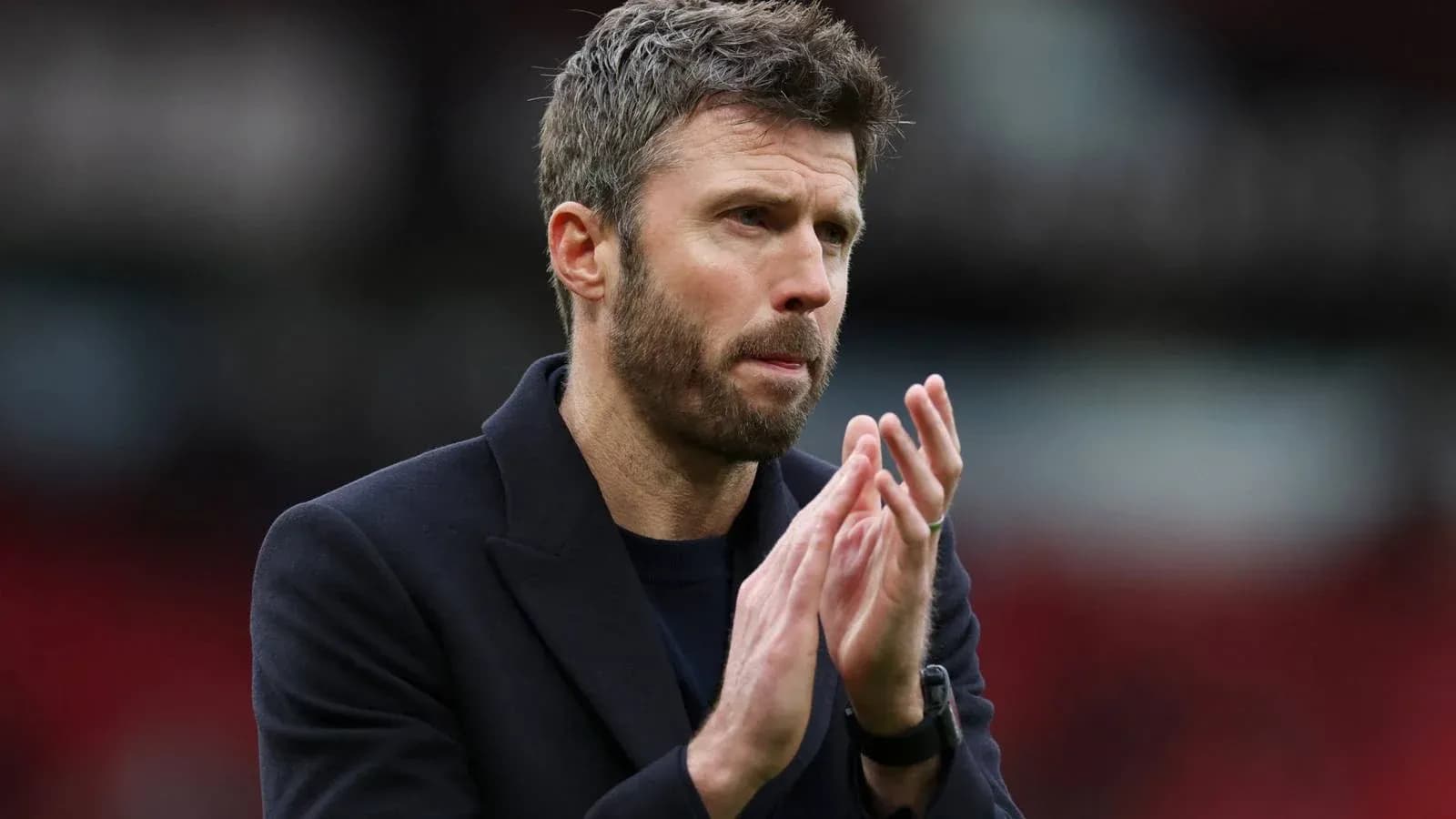Men's football coach applauding on the pitch