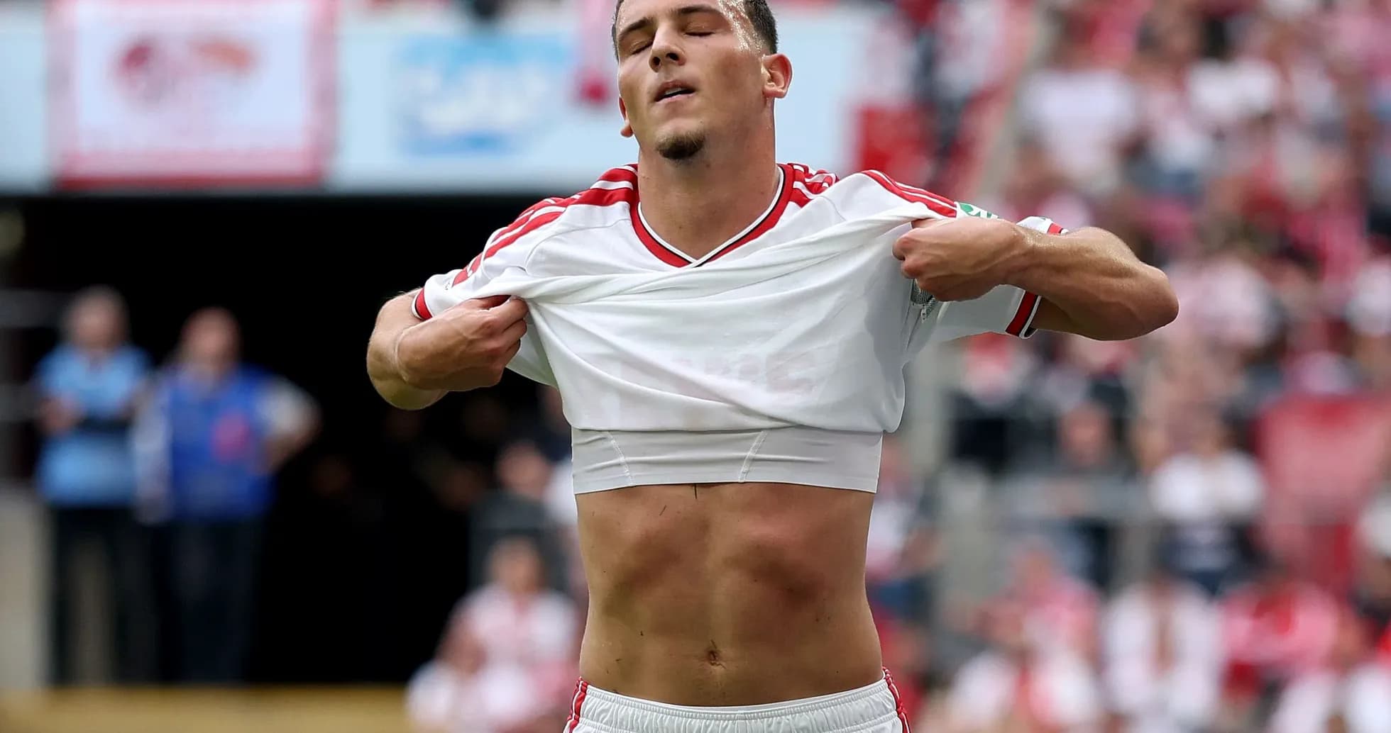 Player lifting shirt during football match celebration