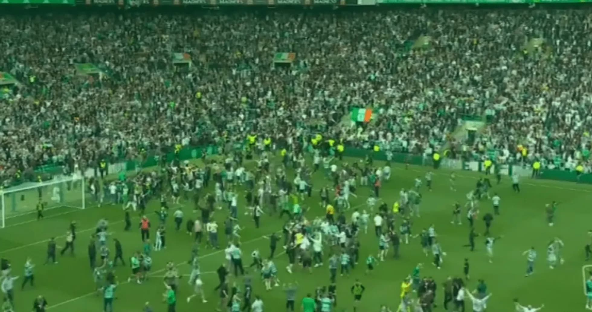 Fans celebrating on the pitch after the match