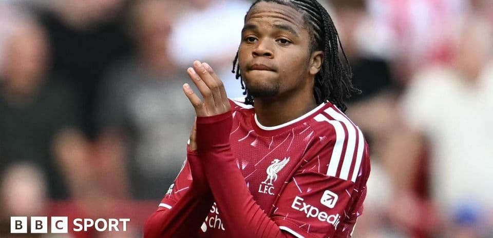 Futbolçu Liverpool formasında, əlini dua edərək göstərir