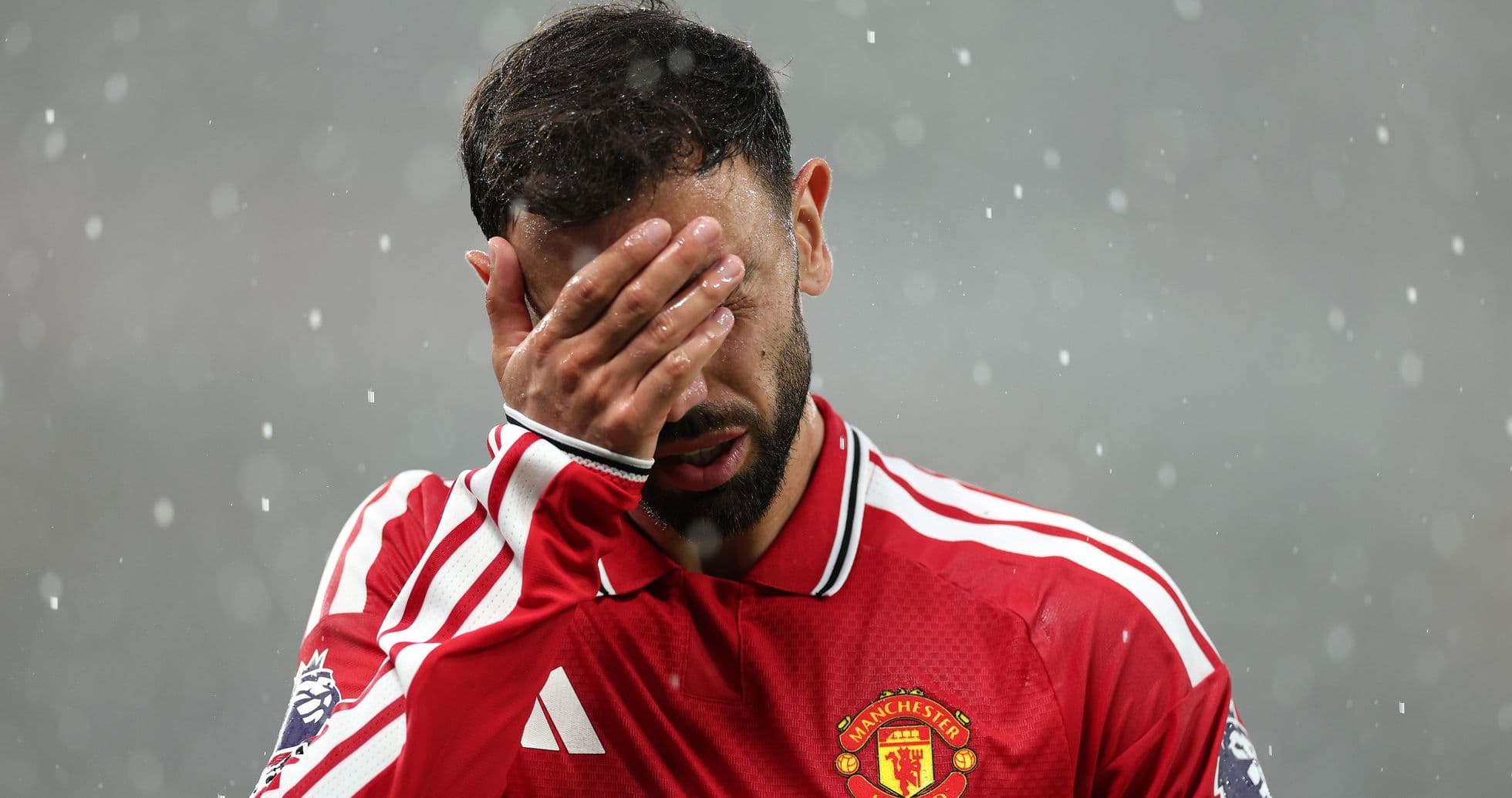 Bruno Fernandes covering his face in rain