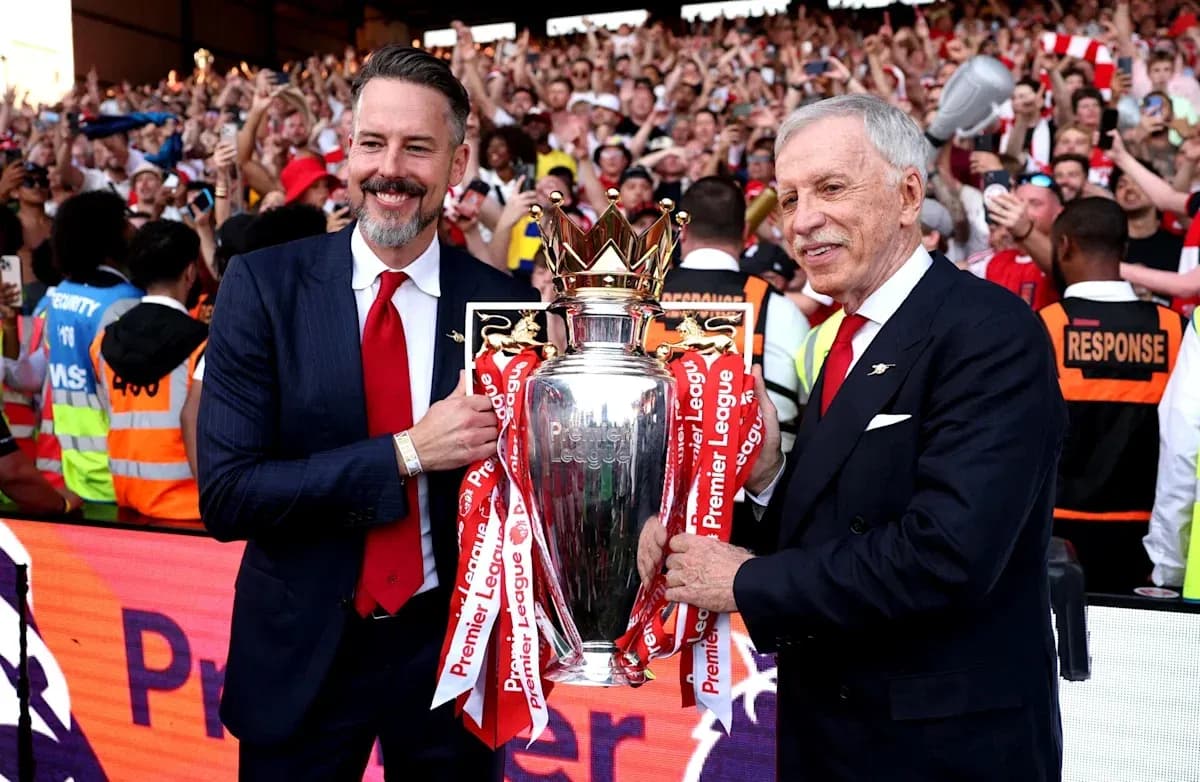 İki kişi Premier League kubokunu tutaraq azarkeşlərə təqdim edir