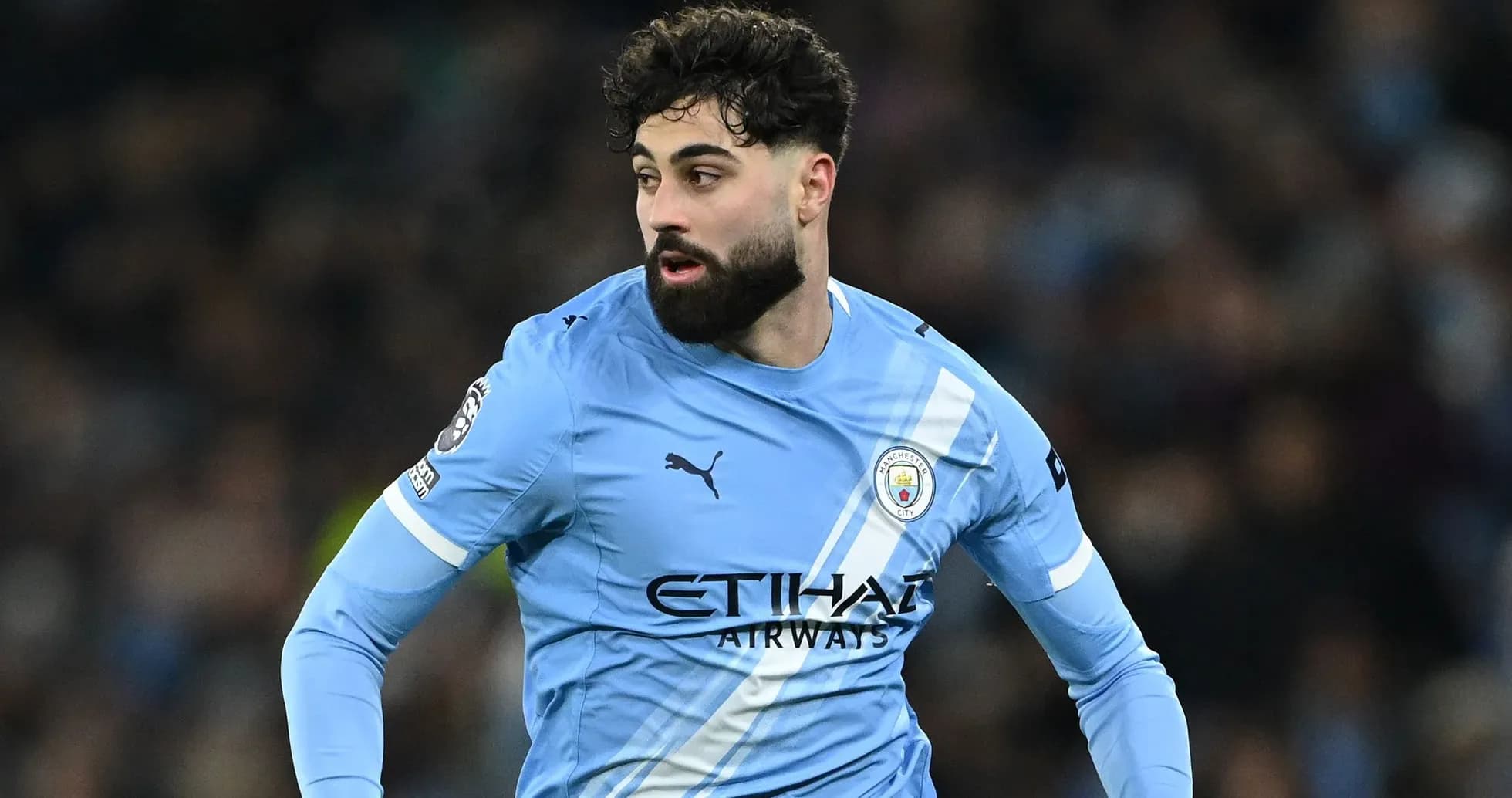 Futbolçu mavi forma ilə meydanda hərəkət edir