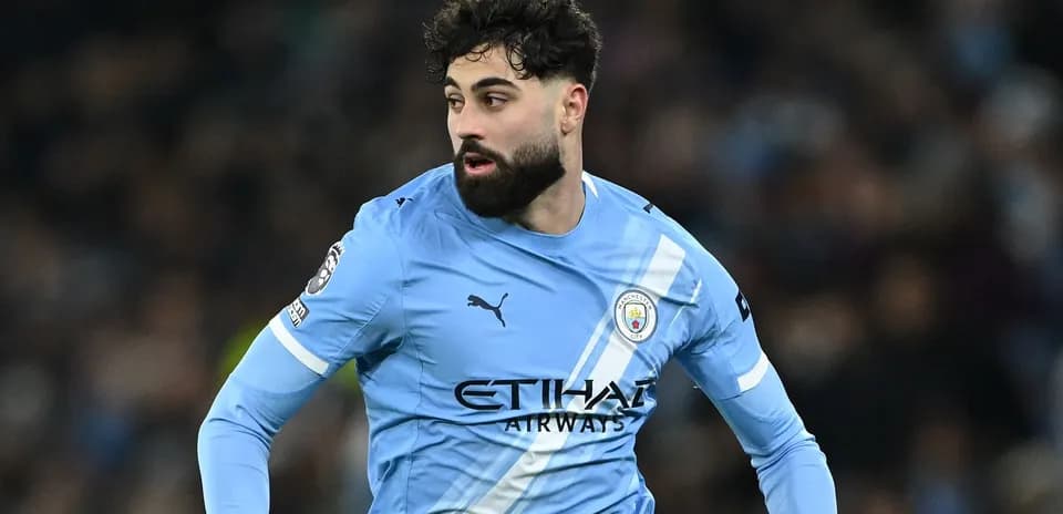 Futbolçu mavi forma ilə meydanda hərəkət edir