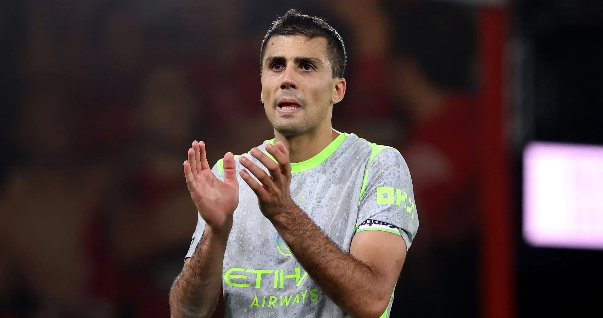 Futbolçu alqış edir, suya batmış forma geyinib Futbolçu alqış edir, suya batmış forma geyinib