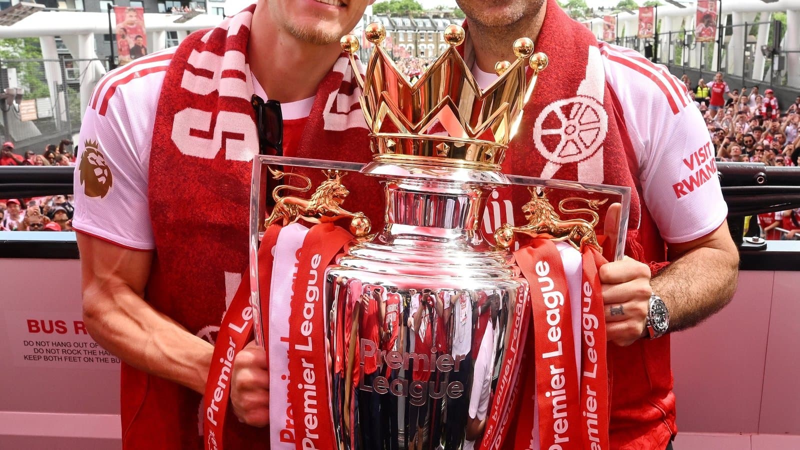 İki futbolçu Premier League kubokunu tutaraq gülümsəyir İki futbolçu Premier League kubokunu tutaraq gülümsəyir