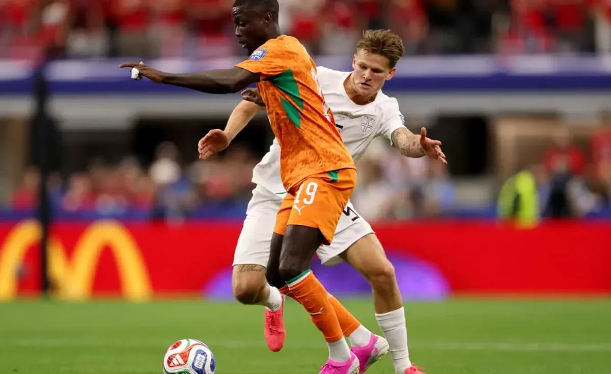 Player in orange jersey evading opponent in white Player in orange jersey evading opponent in white