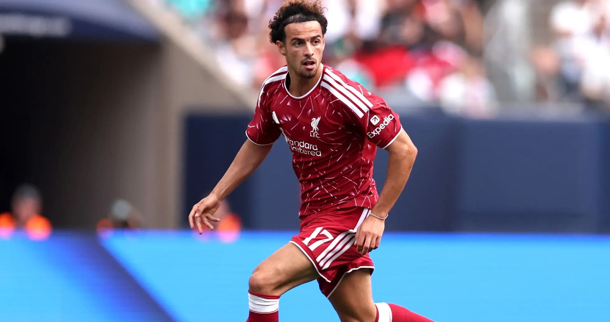 Futbolçu Liverpool formasında topa doğru irəliləyir Futbolçu Liverpool formasında topa doğru irəliləyir
