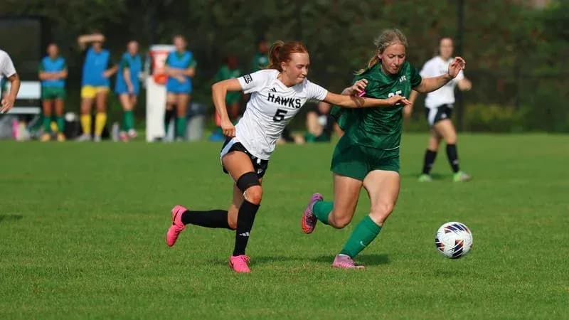 Two players competing for the ball on field Two players competing for the ball on field