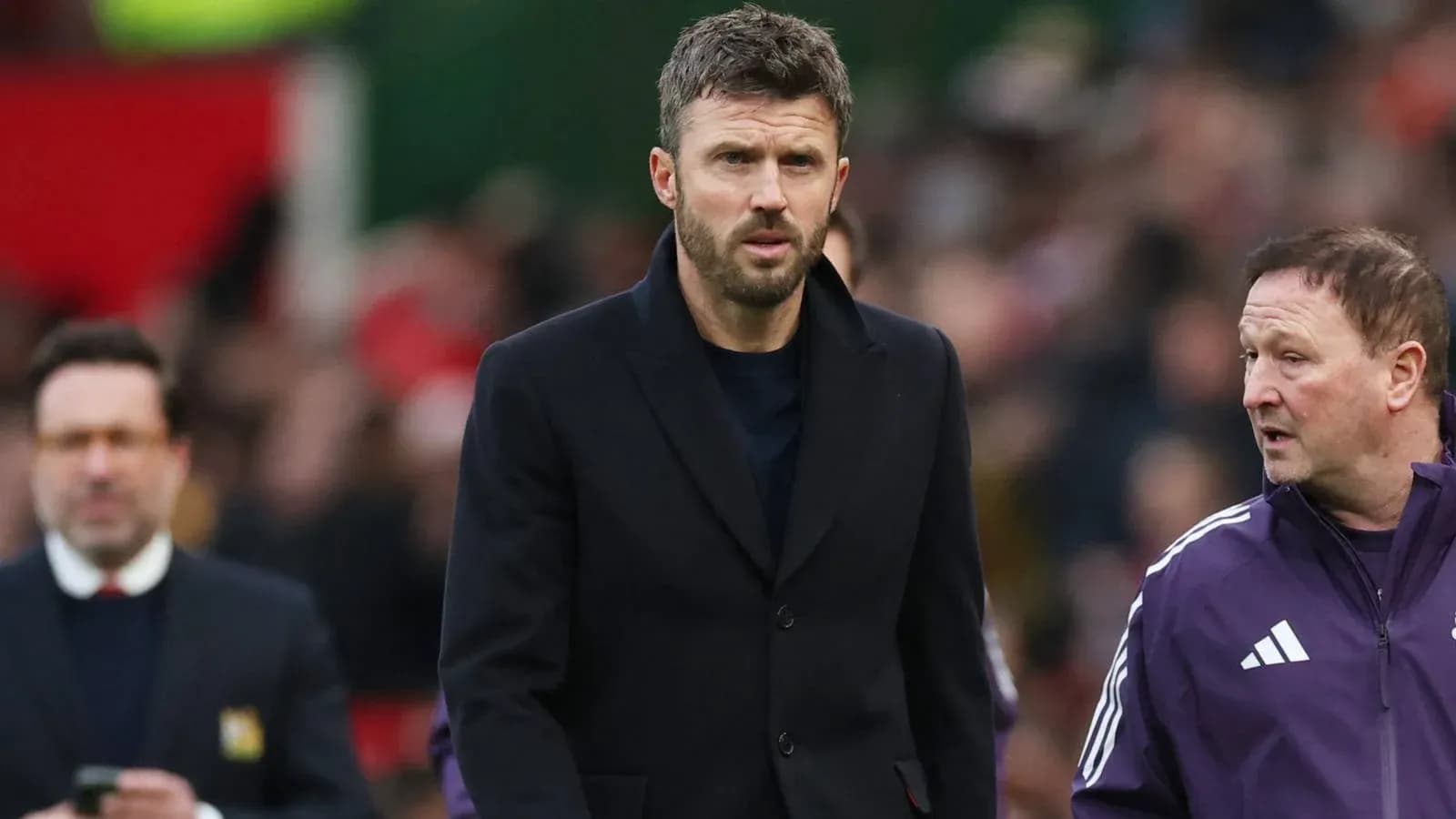 Football manager walking on the pitch with staff Football manager walking on the pitch with staff