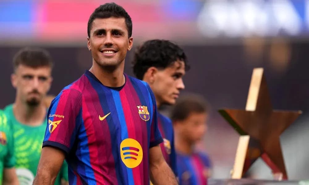 Futbolçu mükafatla podiumda gülərək dayanır Futbolçu mükafatla podiumda gülərək dayanır