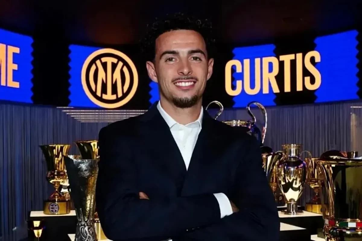 Young man in suit smiling near trophies Young man in suit smiling near trophies