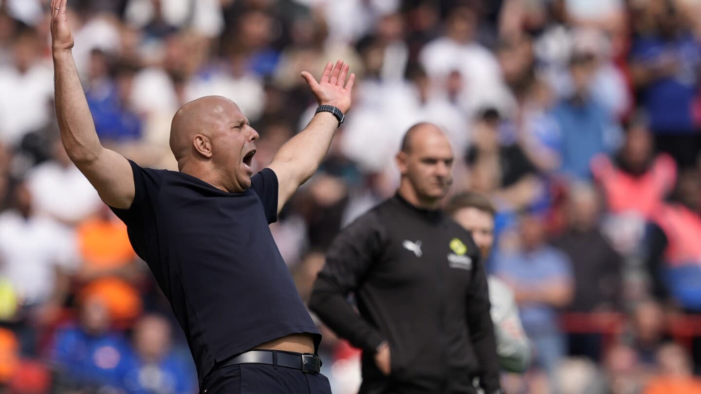 Coach gesturing during match with players in background Coach gesturing during match with players in background