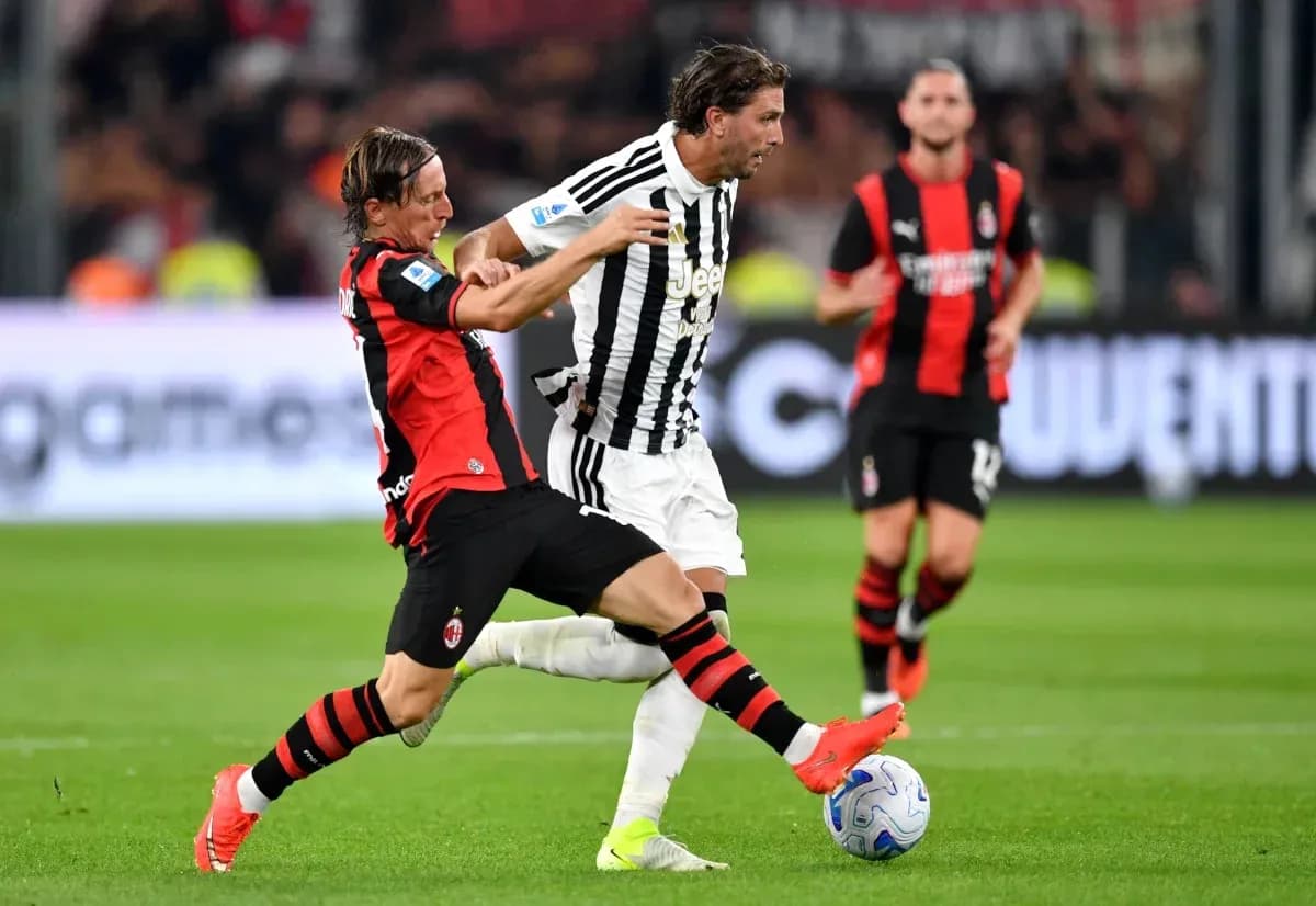 AC Milan player tackles Juventus player during match AC Milan player tackles Juventus player during match