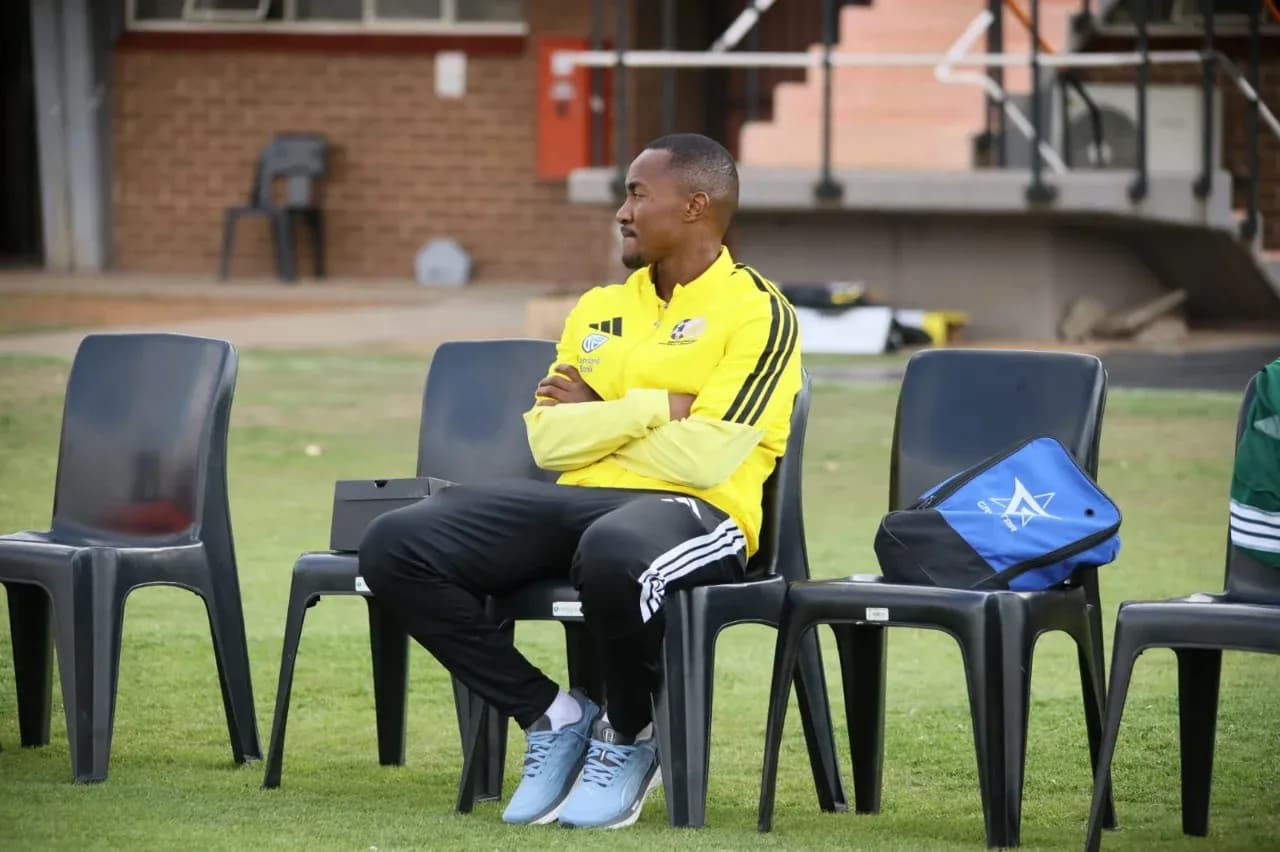 Coach sitting on bench during training session Coach sitting on bench during training session