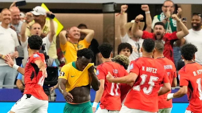 Players celebrating goal with fans in background Players celebrating goal with fans in background