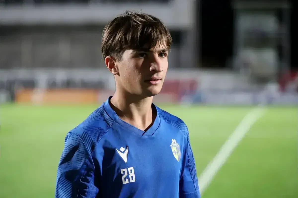 Gənc futbolçu mavi forma ilə meydanda durur Gənc futbolçu mavi forma ilə meydanda durur