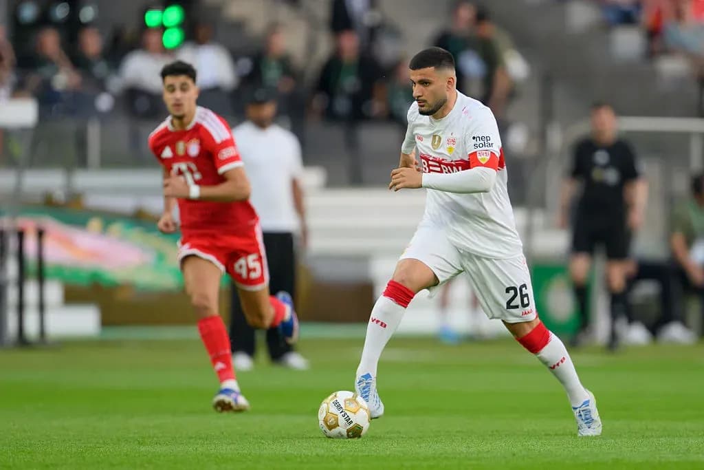 İki futbolçu meydanda top üçün mübarizə aparır İki futbolçu meydanda top üçün mübarizə aparır