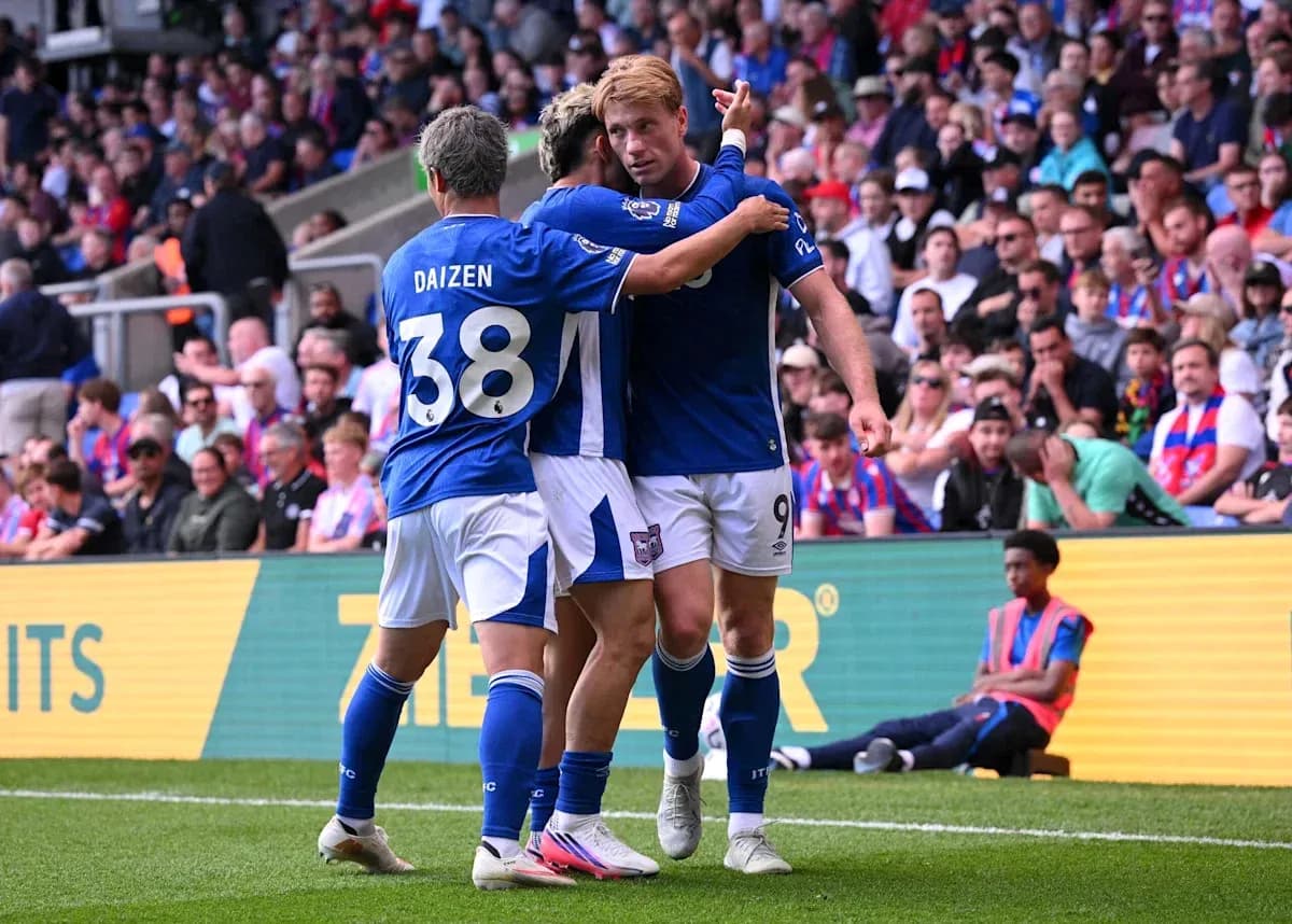 Players celebrating a goal on the pitch Players celebrating a goal on the pitch