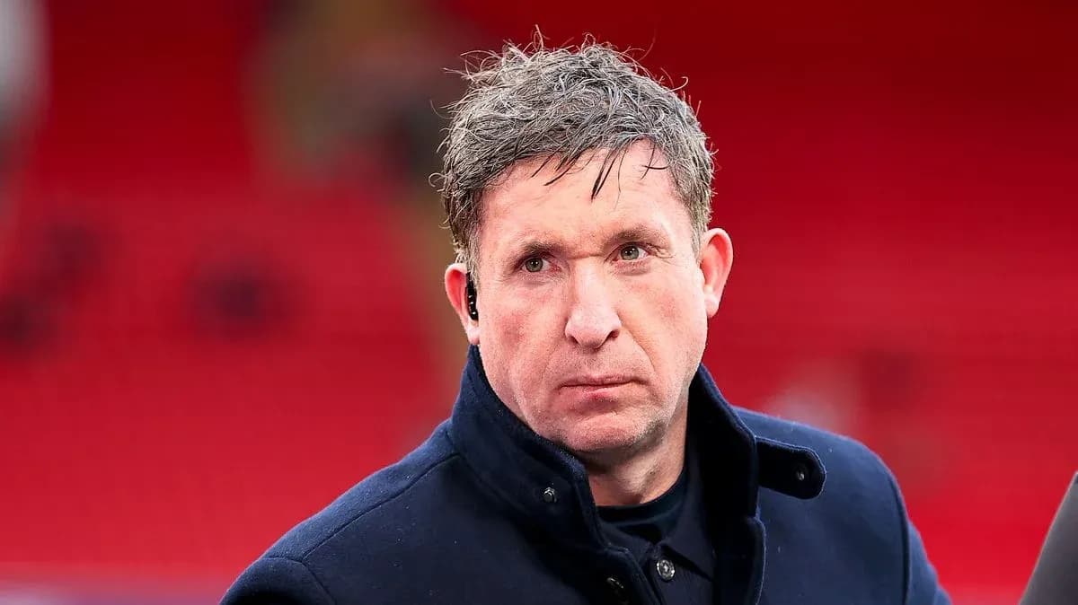 Individual with short hair in a dark coat Individual with short hair in a dark coat