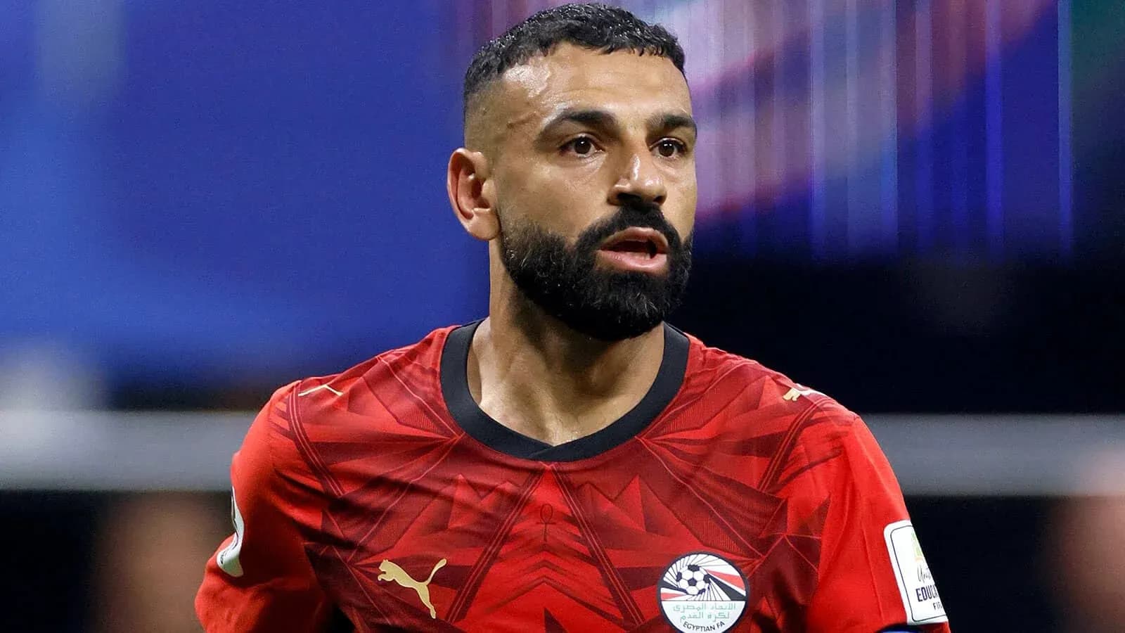 Futbolçu qırmızı forma ilə meydanda hərəkət edir Futbolçu qırmızı forma ilə meydanda hərəkət edir
