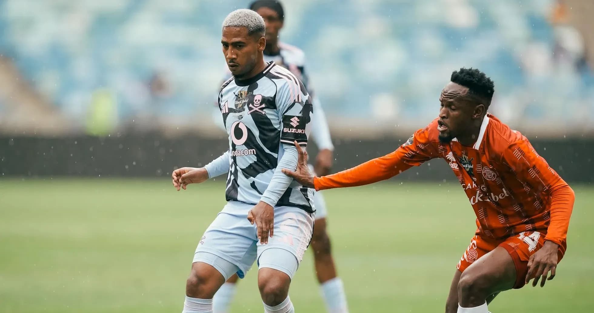 Player in blue jersey evading opponent in orange jersey Player in blue jersey evading opponent in orange jersey