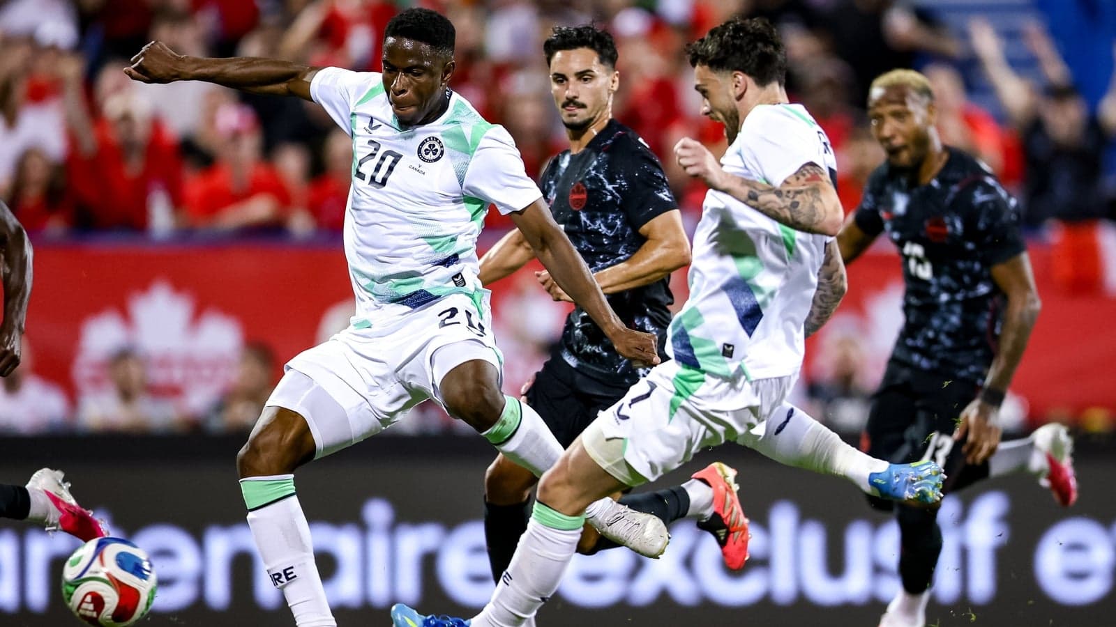 Players competing for the ball during a soccer match Players competing for the ball during a soccer match