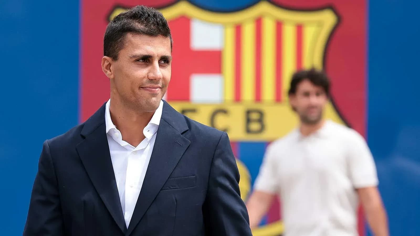 Person in suit near FC Barcelona logo backdrop Person in suit near FC Barcelona logo backdrop