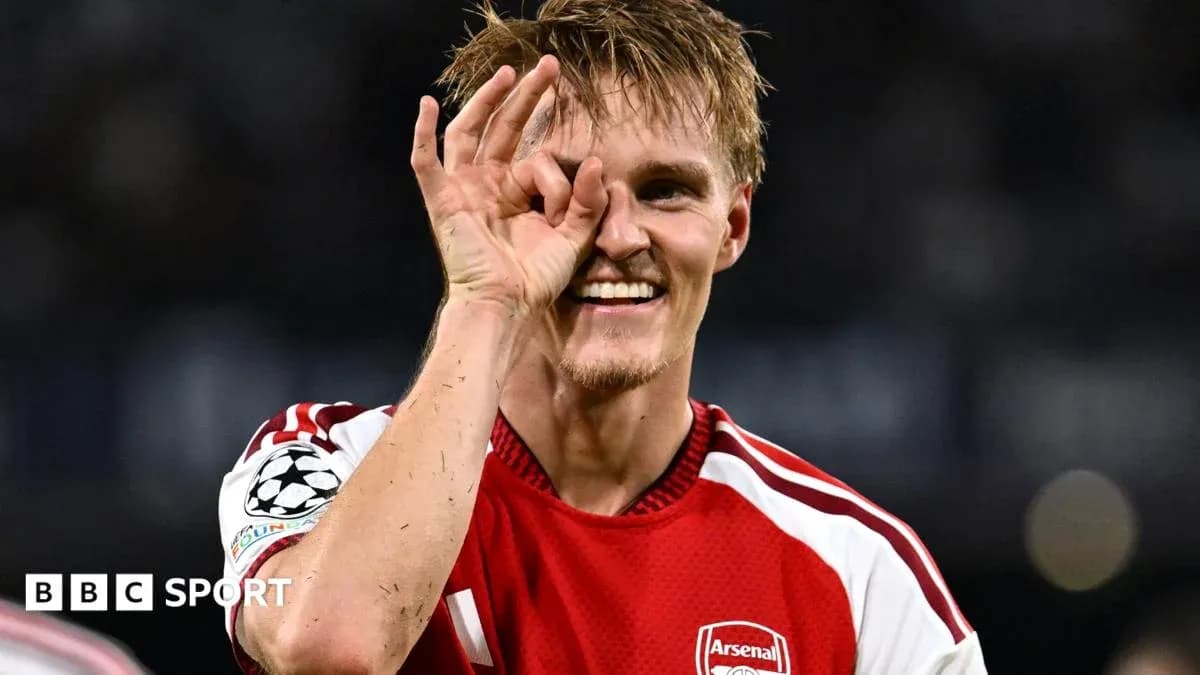 Futbolçu Arsenal formasında gülərək əl işarəsi edir Futbolçu Arsenal formasında gülərək əl işarəsi edir