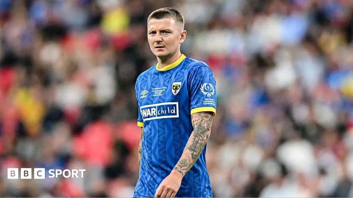 Futbolçu mavi forma ilə meydanda durur Futbolçu mavi forma ilə meydanda durur