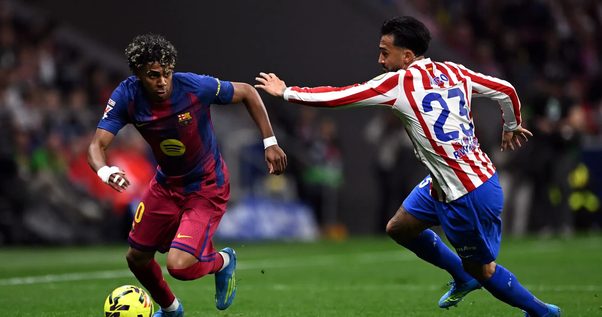 Barcelona player dribbling past Atlético defender Barcelona player dribbling past Atlético defender