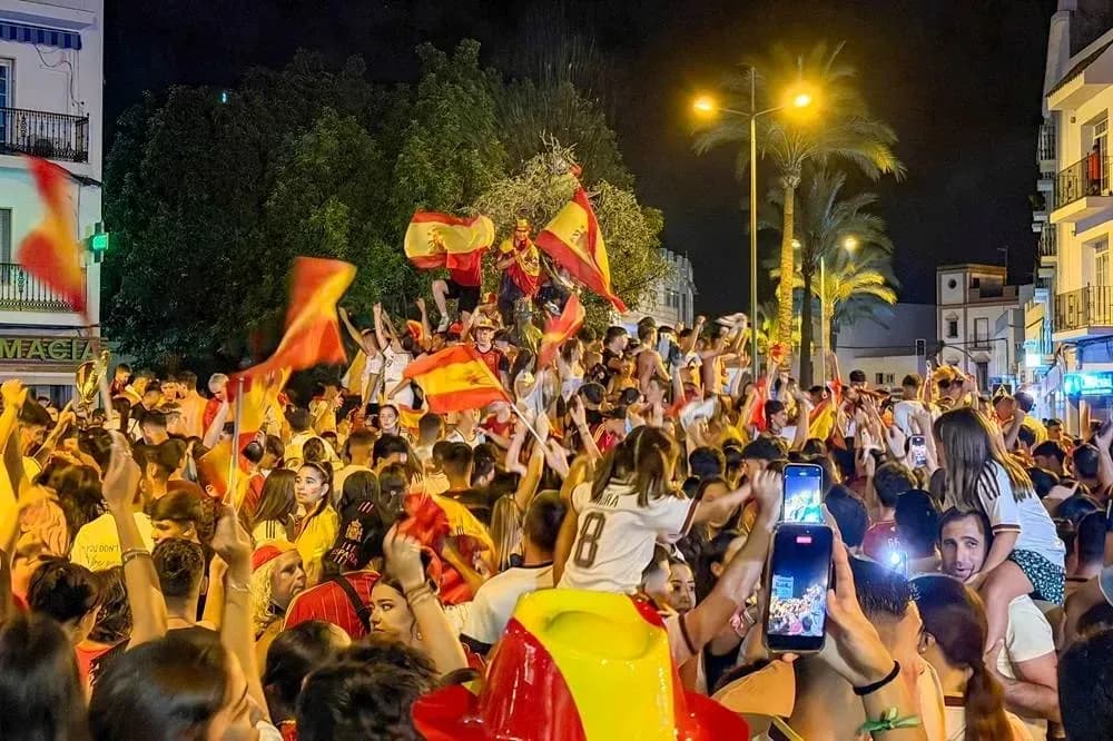 Fans celebrating with flags in street at night Fans celebrating with flags in street at night