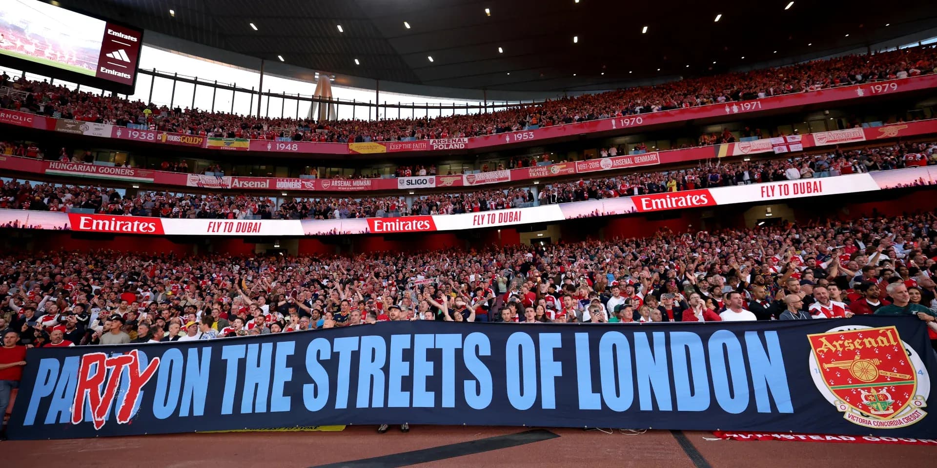 Arsenal fans holding banner in stadium stands Arsenal fans holding banner in stadium stands