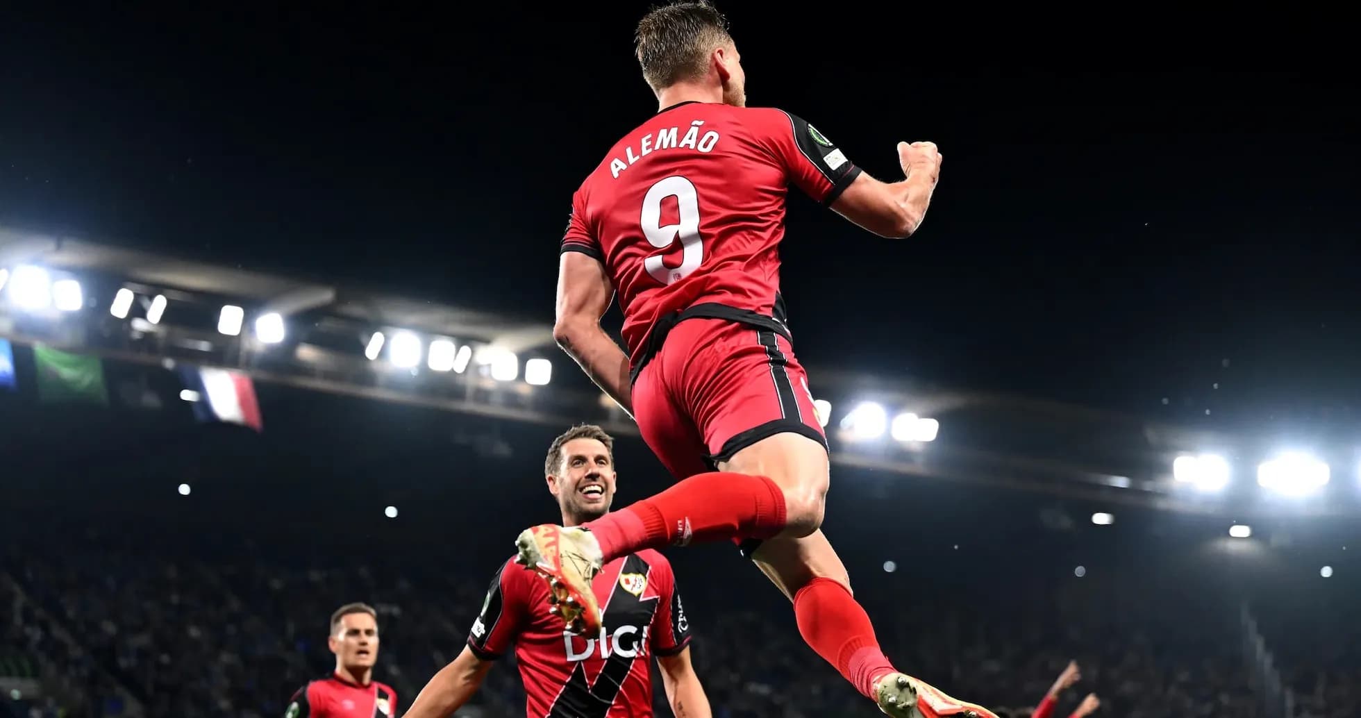 Player celebrating a goal with teammates in match Player celebrating a goal with teammates in match