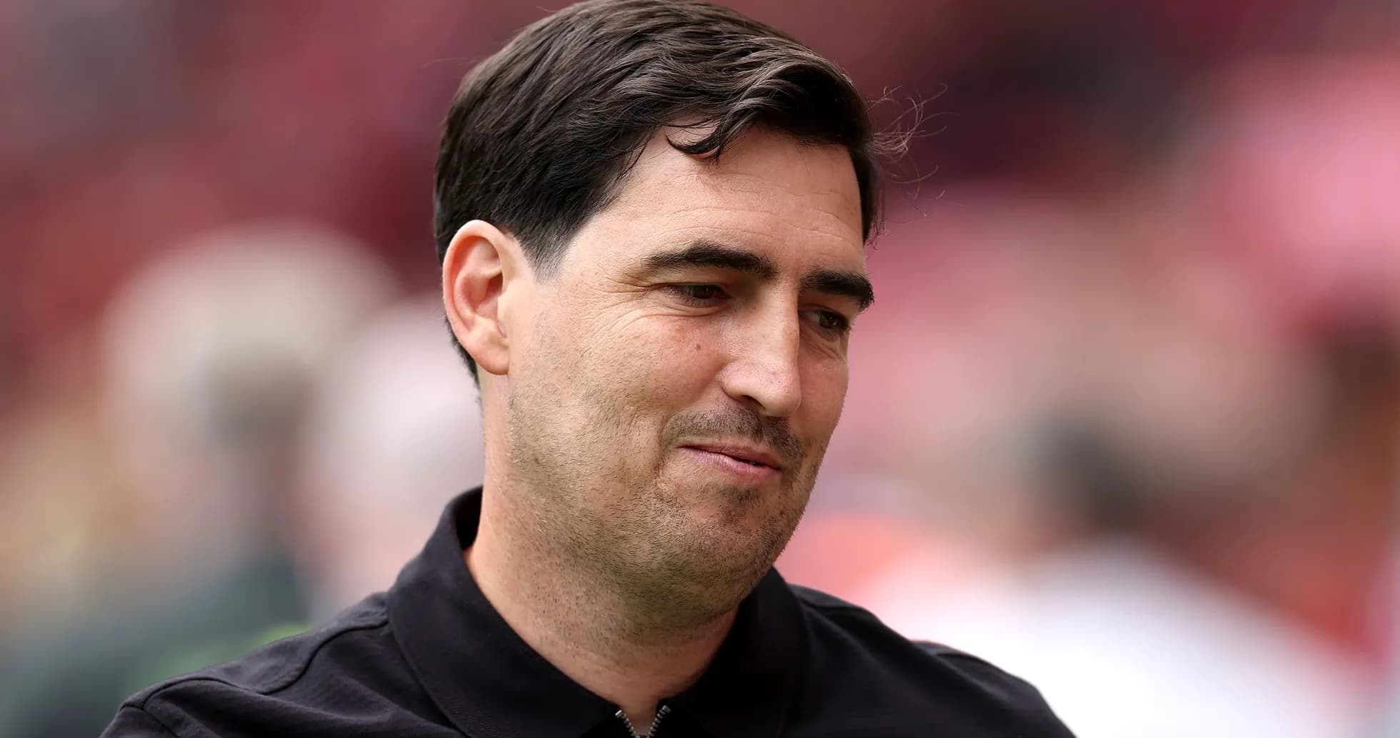 A man in a black shirt smiling slightly A man in a black shirt smiling slightly