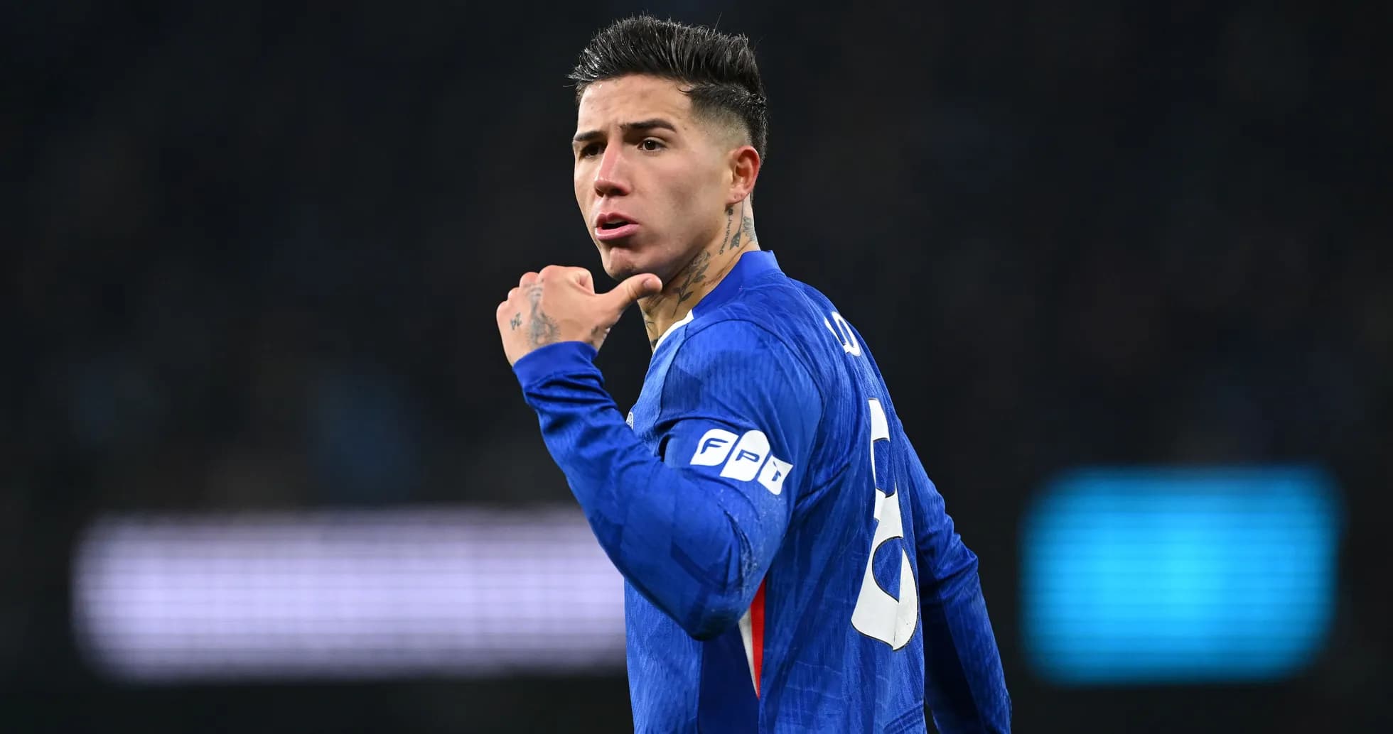 Futbolçu mavi forma ilə meydanda əlləri ilə işarə edir Futbolçu mavi forma ilə meydanda əlləri ilə işarə edir