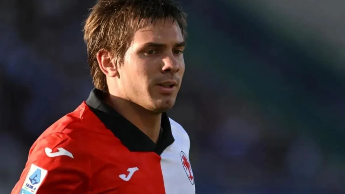 Futbolçu meydanda qırmızı və ağ forma geyinib Futbolçu meydanda qırmızı və ağ forma geyinib